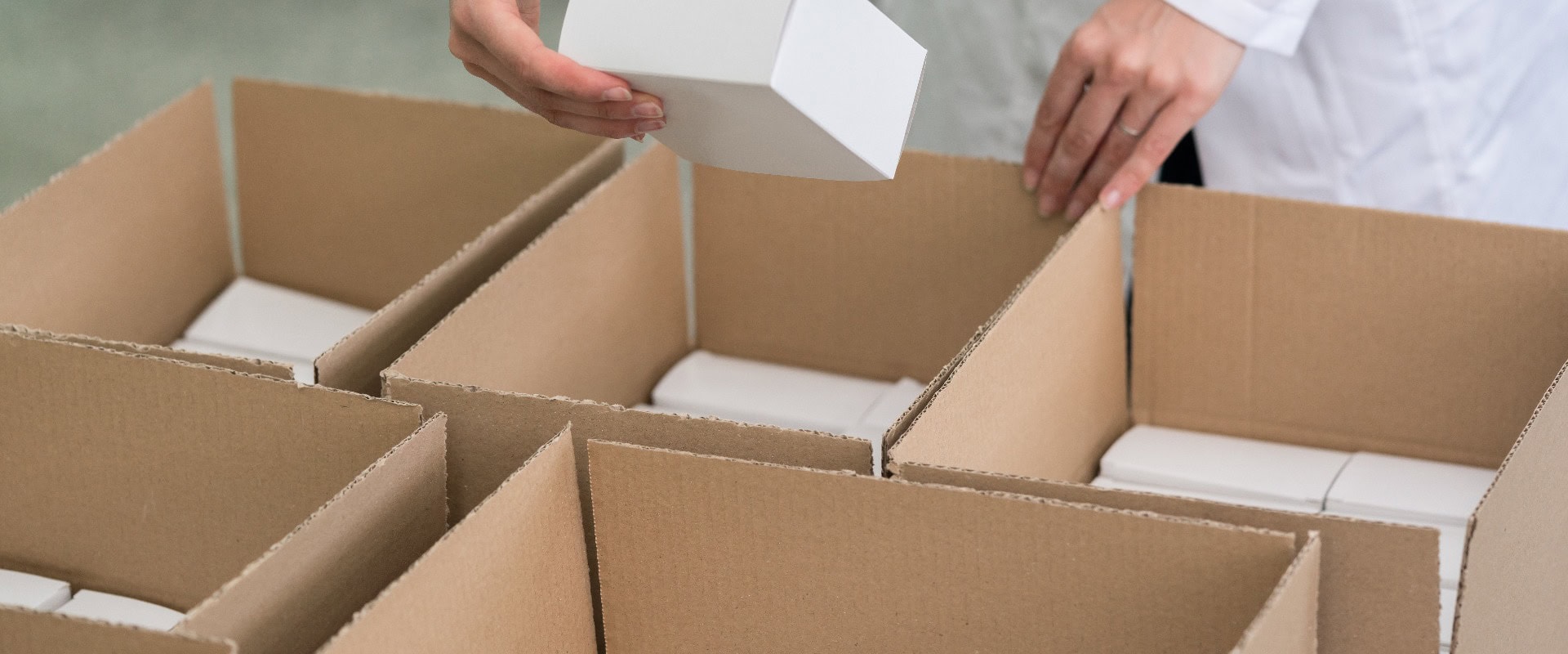 Ein Arbeiter, der verpackte Produkte in Kartons legt
